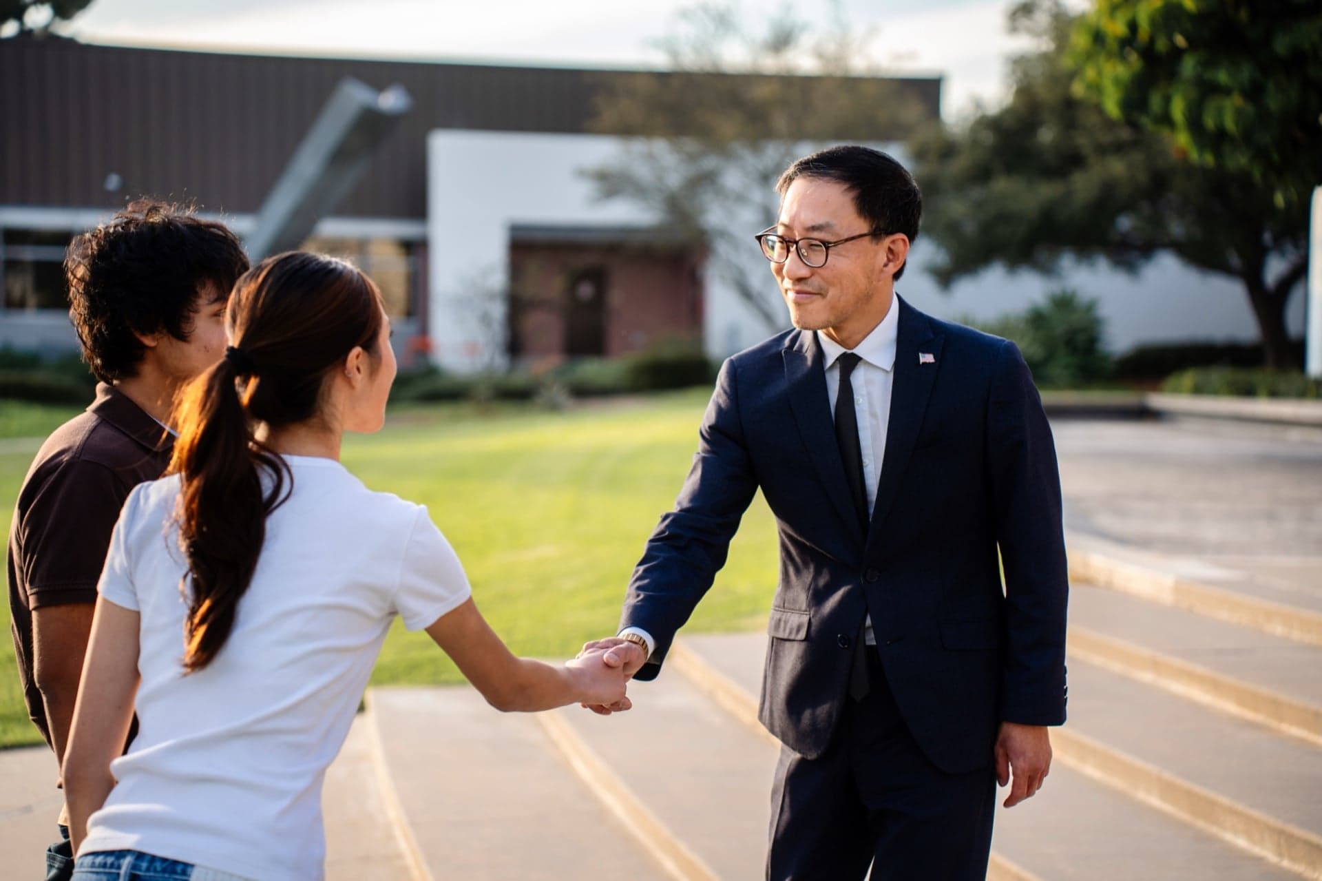 Fred Jung shaking hands with community members